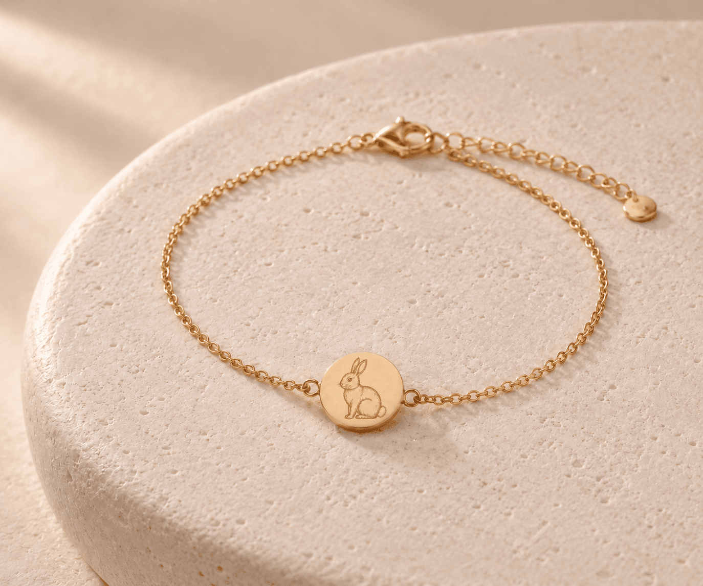 Rabbit zodiac gold-tone chain bracelet design concept on an ivory stone platform