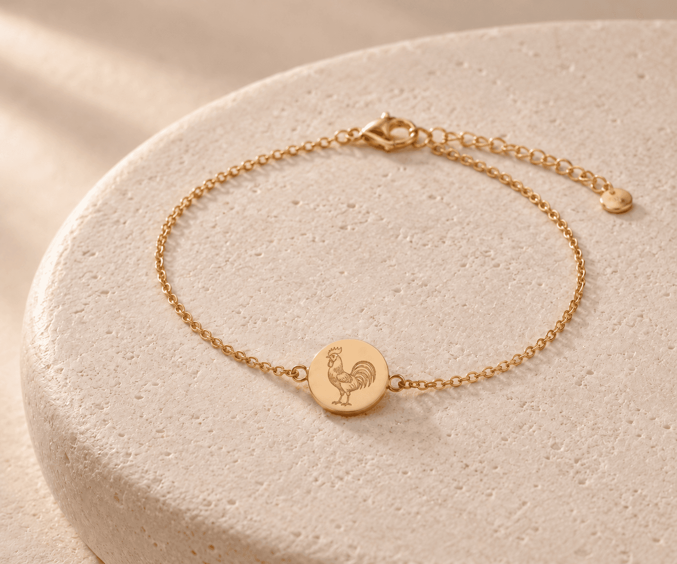 Rooster zodiac gold-tone chain bracelet design concept on an ivory stone platform