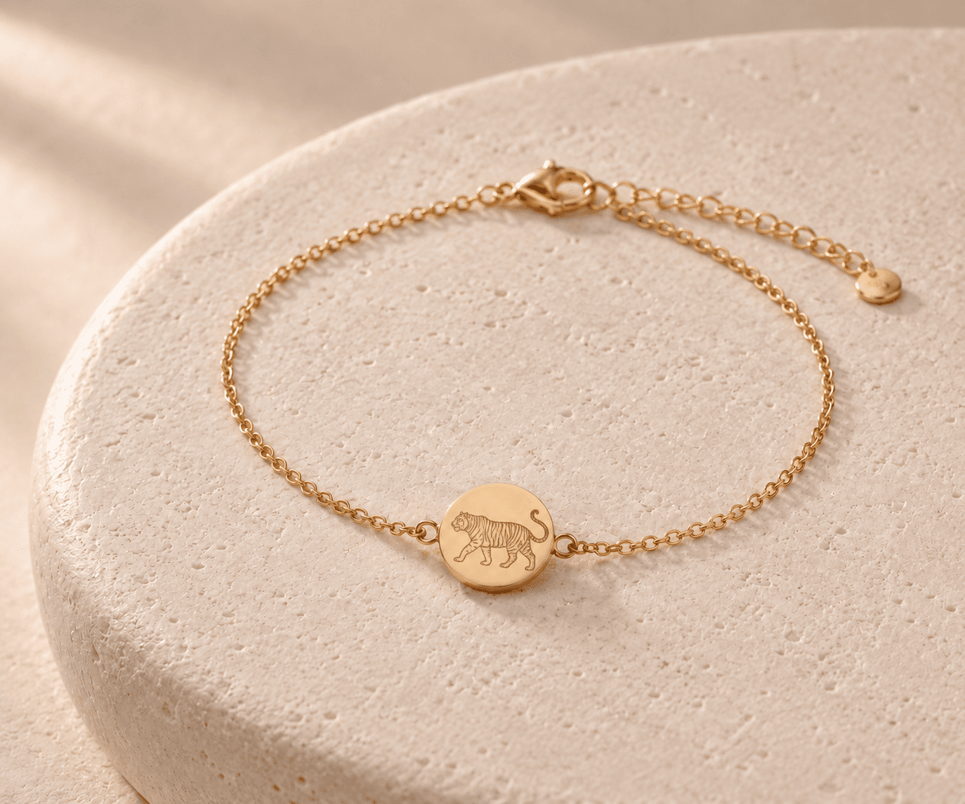 Tiger zodiac gold-tone chain bracelet design concept on an ivory stone platform